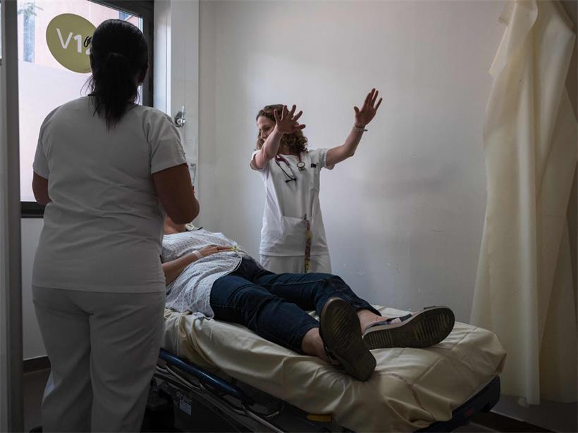 Médecin examinant une patiente souffrant de la chaleur extrême dans un hôpital de Toulouse, soins médicaux d'urgence