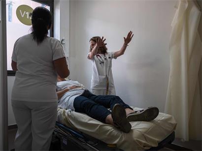 Médecin examinant une patiente souffrant de la chaleur extrême dans un hôpital de Toulouse, soins médicaux d'urgence