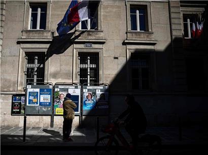 Person betrachtet Wahlplakate der letzten drei Pariser Bürgermeisterkandidaten während der Kommunalwahl