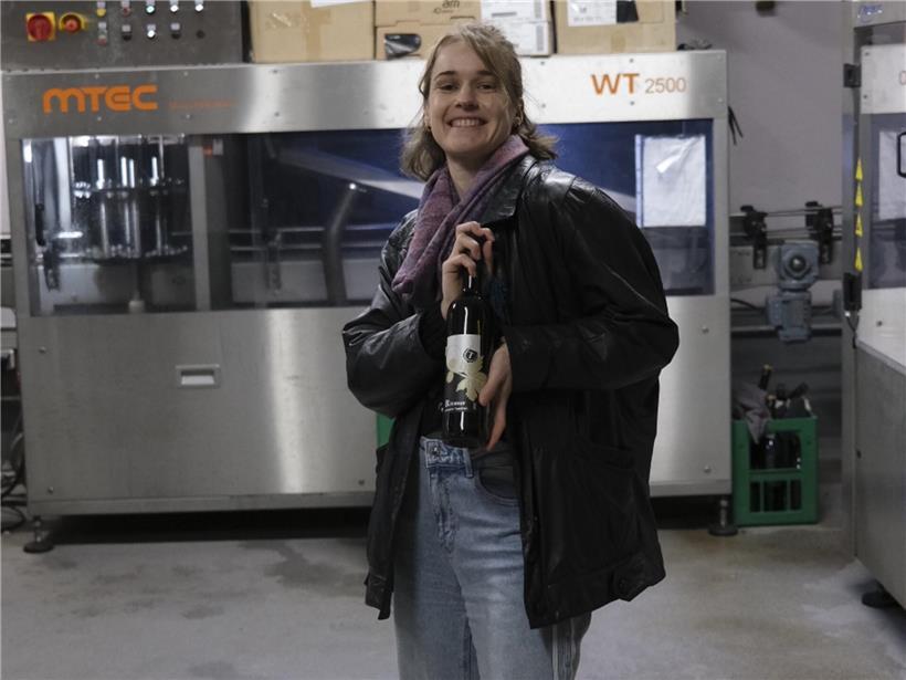 Grafikerin Kim Kieffer präsentiert eine der ersten etikettierten Flaschen im Designstudio