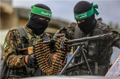Vermummte Kämpfer der Kassam-Brigaden, des militärischen Flügels der islamistischen Terrororganisation Hamas, hantieren mit Waffen
