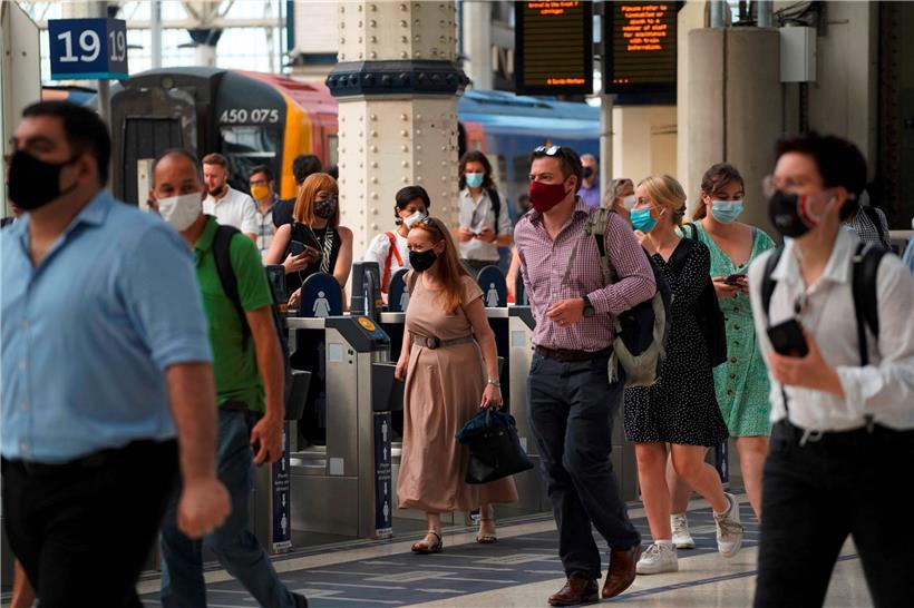 Viele Menschen trauen der Sache noch nicht und behalten die Maske lieber an, wie hier im Londoner Bahnhof Waterloo zu sehen ist

