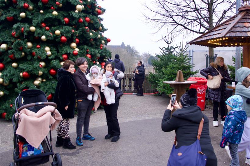 Viele Touristen machen Fotos und Selfies vor den riesigen Weihnachtsbäumen und d...