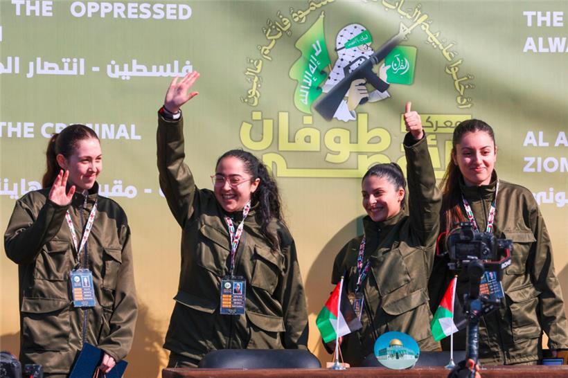 Vier israelische Geiseln winken auf einer Bühne, bevor Hamas-Kämpfer sie an ein Team des Roten Kreuzes in Gaza-Stadt übergeben
