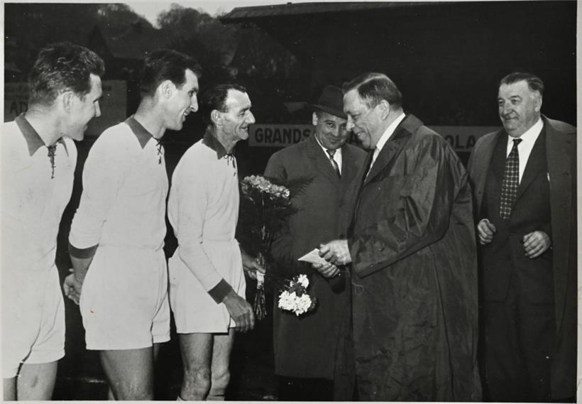 Virum Match: Den Antoine Krier, Buergermeeschter vun Esch, begréisst den Emile Mond. Riets de Schäffe Jules Schreiner, donieft den Nic Waldbillig.
