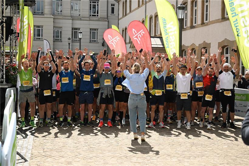 Motivierte Läuferin voller Vorfreude vor dem Start eines Straßenrennens bei sonnigem Wetter