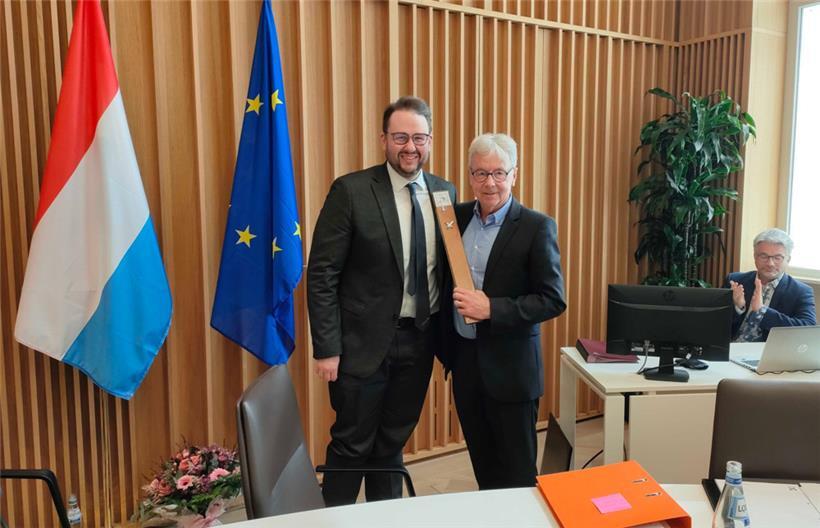 Von Bürgermeister Christian Weis (l.) bekam Jean Tonnar als Abschiedsgeschenk ein Stück des alten Parkettbodens des vor drei Jahren runderneuerten Sitzungssaals
