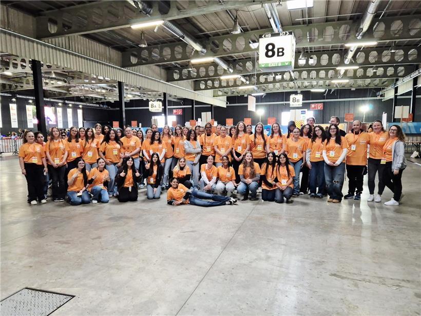 Schülerinnen in Schuluniformen posieren vor der Arbeit für ein Gruppenfoto im Freien