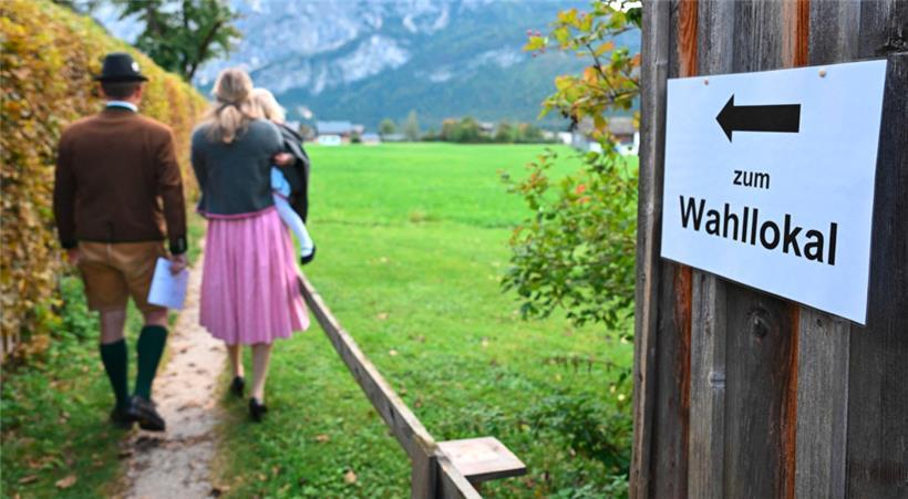 Wähler in traditioneller Kleidung auf dem Weg zu einem Wahllokal in Altaussee
