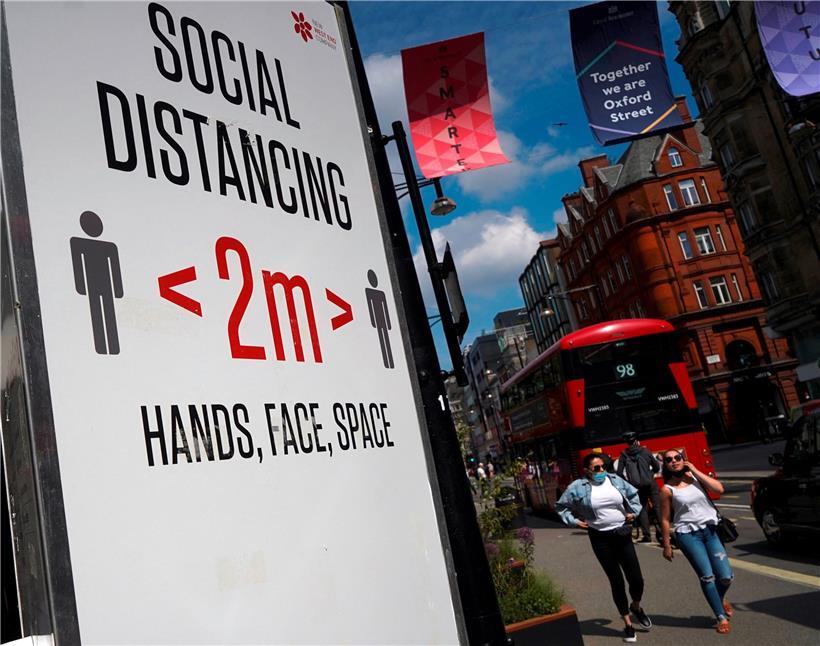 Warntafel in der Londoner Oxford Street: In Großbritannien werden die Lockerungen von Einschränkungen vorerst vertagt
