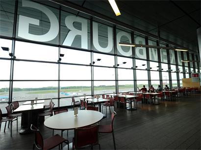 Flugzeug am Gate mit Verspätungsanzeige – Tipps bei Flugverspätung und Rechten als Passagier