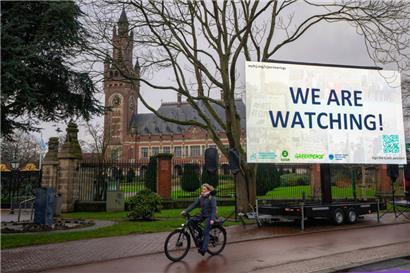 «We are Watching!» ist auf einem Plakat vor dem Internationalen Gerichtshof zu lesen
