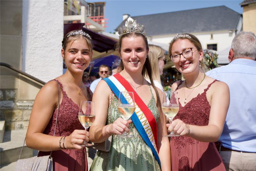 Weinkönigin Anne-Catherine (M.) und ihre Prinzessinnen Anne und Jill heben die B...