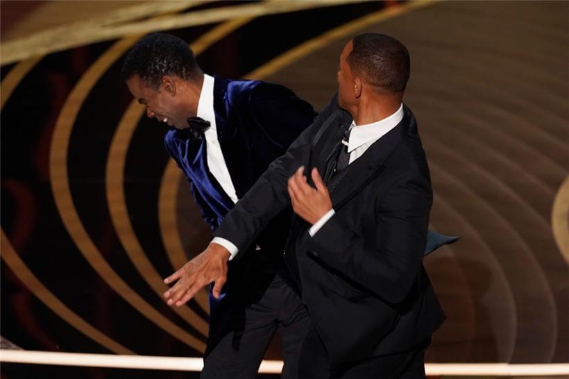 Will Smith (r) schlägt Moderator Chris Rock auf der Bühne, während er den Preis für den besten Dokumentarfilm bei den Oscars, der 94. Verleihung der Academy Awards, überreicht
