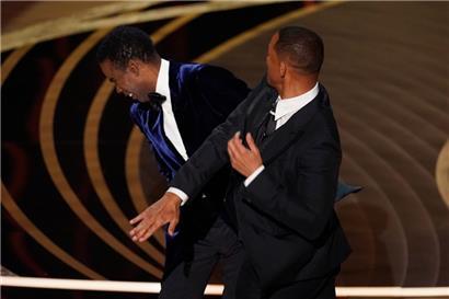 Will Smith (r) schlägt Moderator Chris Rock auf der Bühne, während er den Preis für den besten Dokumentarfilm bei den Oscars, der 94. Verleihung der Academy Awards, überreicht
