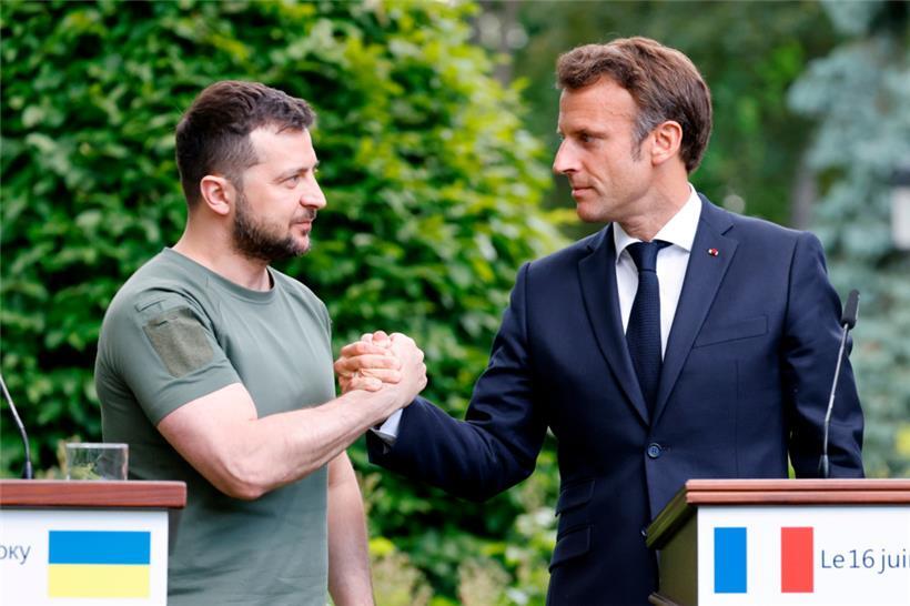 Wolodymyr Selenskyj (l), Präsident der Ukraine, und Emmanuel Macron, Präsident von Frankreich, reichen sich am 16.06.2022 nach einer Pressekonferenz die Hand. 
