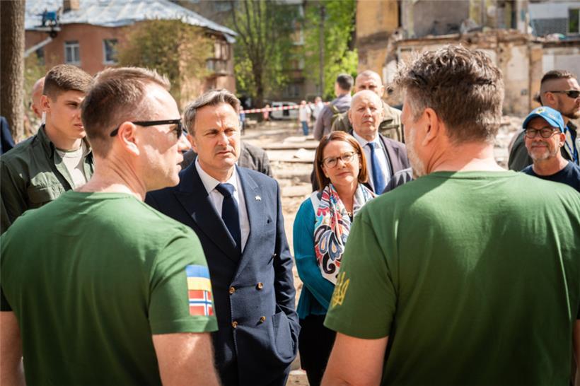 Xavier Bettel und Yuriko Backes im Gespräch mit Helfern in Kiew: An dieser Stelle traf eine ballistische Rakete aus Russland am 24. April ein Wohnviertel – mehrere Zivilisten, darunter ein 17-jähriger Junge, kamen ums Leben
