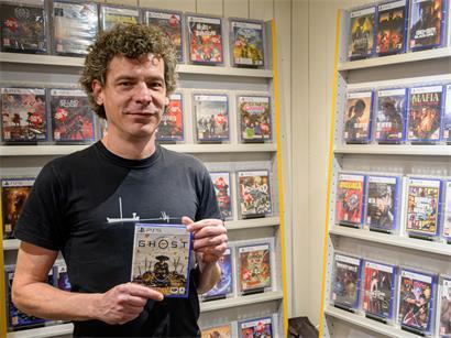 Xavier posiert vor seinem noch gut bestückten Regal mit einem PlayStation-5-Spiel – bald ein Relikt aus der Vergangenheit?