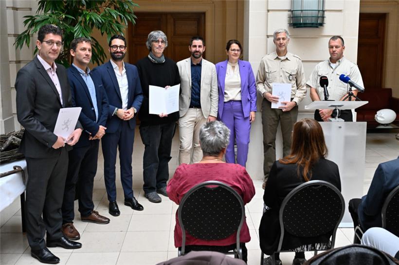 Yves Krippel steht rechts neben Kulturminister Eric Thill und zeigt die Bescheinigung zum „Louschläissen“ 
