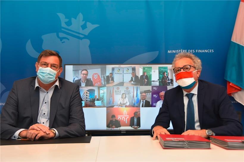 Yves Maas von der Bankenvereinigung ABBL und Finanzminister Pierre Gramegna bei der Unterzeichnung des Abkommens über Staatsgarantien für Unternehmenskredite
