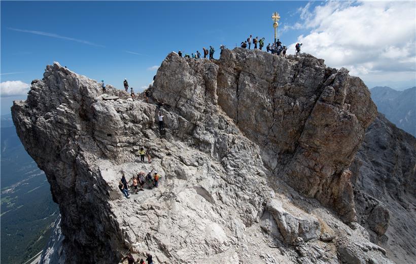 Zahlreiche Ausflügler nutzen das schöne Wetter für einen Ausflug zum Gipfelkreuz auf der Zugspitze
