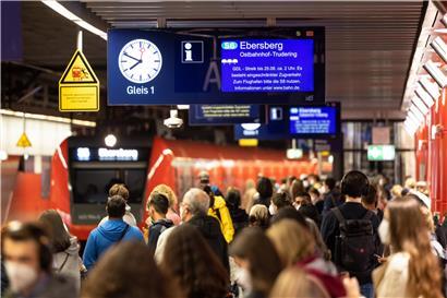 Zahlreiche Menschen warten an einem Bahnsteig auf eine einfahrende S-Bahn, während auf einer Anzeigetafel über ihnen auf den laufenden Streik der Lokführergewerkschaft GDL hingewiesen wird
