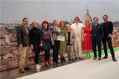 Zeit für ein Gruppenfoto: Die Produzenten und Schauspieler lächeln gemeinsam mit der Regisseurin in die Kamera
