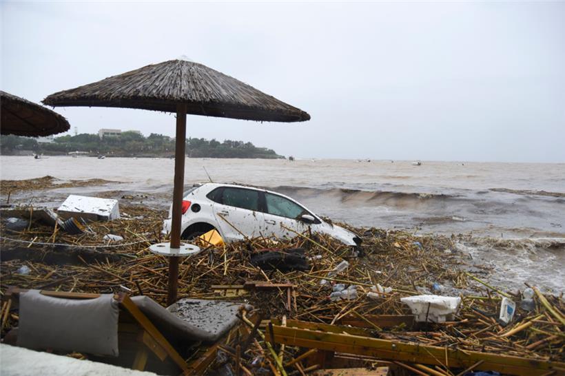 Zerstörte Autos, die von den Wassermassen an den Strand getragen wurden
