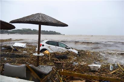 Zerstörte Autos, die von den Wassermassen an den Strand getragen wurden
