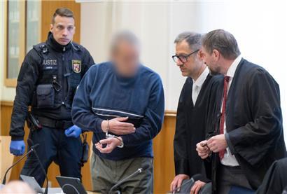 Zum Prozessauftakt wird ein mutmaßliches Mitglied der Terrorgruppe „Vereinte Patrioten“ in den Verhandlungssaal gebracht und unterhält sich mit seinen Verteidigern
