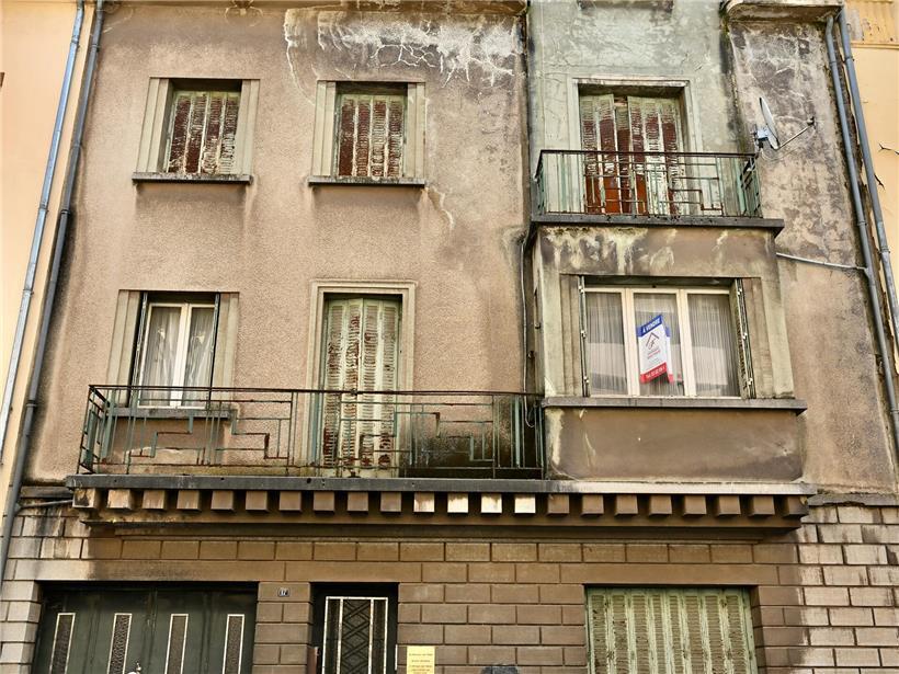 Altes Haus in renovierungsbedürftigem Zustand mit verwitterter Fassade und leerem Fensterrahmen