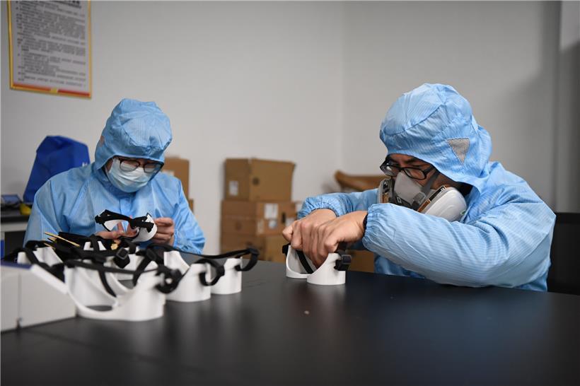 Zwei Arbeiter fertigen im Forschungs- und Anwendungszentrum für additive Fertigung der Hunan Vanguard Group eine Brille an. Das Unternehmen hat in letzten Wochen mit mehr als 50 3D-Druckern, die Tag und Nacht arbeiten, Brillen für den medizinischen Gebrauch hergestellt.
