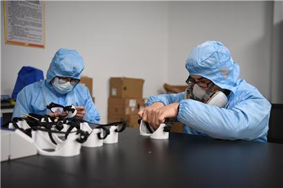 Zwei Arbeiter fertigen im Forschungs- und Anwendungszentrum für additive Fertigung der Hunan Vanguard Group eine Brille an. Das Unternehmen hat in letzten Wochen mit mehr als 50 3D-Druckern, die Tag und Nacht arbeiten, Brillen für den medizinischen Gebrauch hergestellt.
