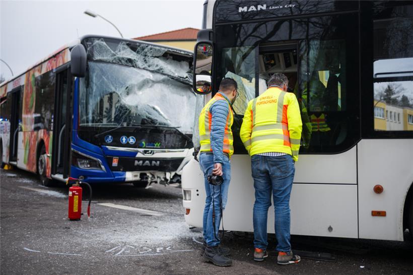 Zwei Einsatzkräfte der Unfall-Forschung arbeiten am Unfallort. Zwei Linienbusse sind am Montag auf einer Kreuzung in Saarbrücken frontal zusammengestoßen
