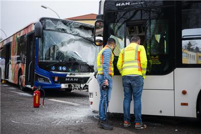 Zwei Einsatzkräfte der Unfall-Forschung arbeiten am Unfallort. Zwei Linienbusse sind am Montag auf einer Kreuzung in Saarbrücken frontal zusammengestoßen
