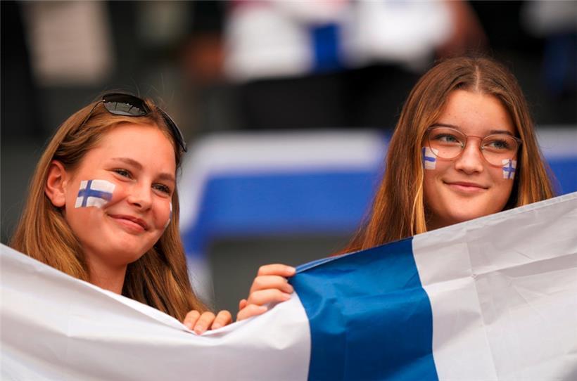 Zwei Finnland-Fans lächeln vor einem Fußball-Spiel
