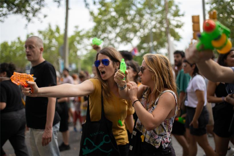 Zwei Frauen halten Wasserpistolen während einer Demonstration gegen den Massentourismus in Barcelona
