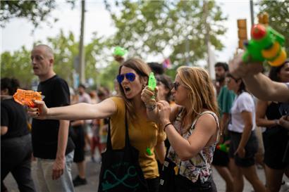 Zwei Frauen halten Wasserpistolen während einer Demonstration gegen den Massentourismus in Barcelona
