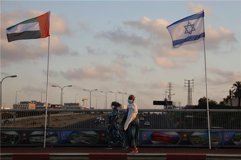 Zwei Frauen mit Schutzmasken gehen an den Flaggen von Israel und den Vereinigten Arabischen Emiraten auf der Friedensbrücke vorbei. Nach der angekündigten Normalisierung ihrer Beziehungen steuern Israel und die Vereinigten Arabischen Emirate in schnellen Schritten auf einen regelmäßigen diplomatischen Kontakt zu.

