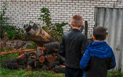 Zwei Jungen betrachten die Überreste einer Rakete, die in der Nähe einer Gebäudewand in Kramatorsk, Region Donezk, am 4. Oktober 2022 inmitten der russischen Invasion in der Ukraine eingeschlagen ist
