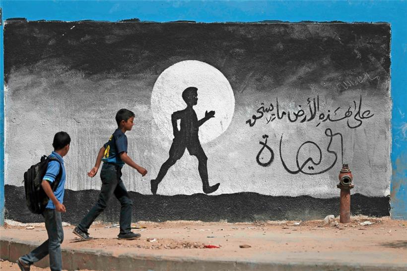 Zwei Schuljungen laufen entlang einer Mauer der Schule der Vereinten Nationen in Beit Hanun im nördlichen Teil des Gazastreifens

