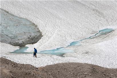 Zwei Wanderer gehen über den Schneeferner-Gletscher auf der Zugspitze
