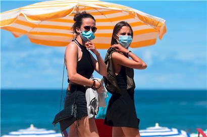 Zwei junge Damen flanieren an der Strandpromenade des französischen Urlaubsorts Biarritz
