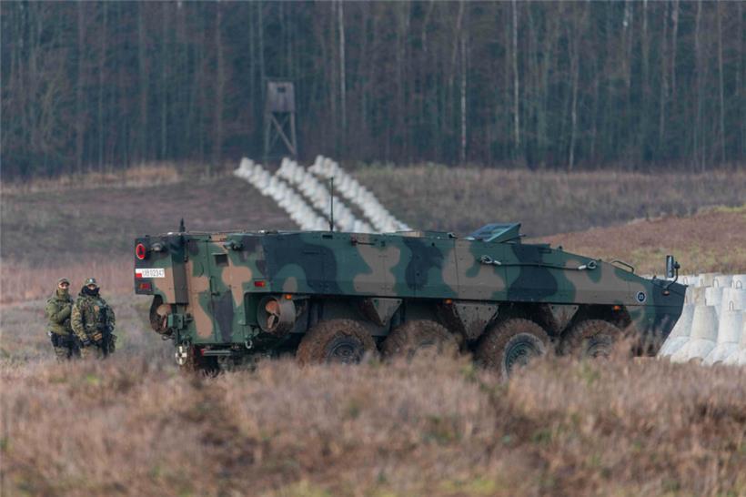 Zwei polnische Soldaten stehen neben einem gepanzerten Fahrzeug an der polnisch-russischen Grenze nahe der Ortschaft Dabrowka im Norden Polens

