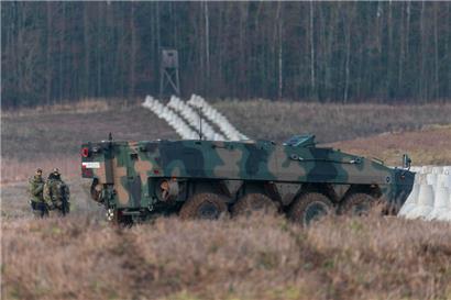 Zwei polnische Soldaten stehen neben einem gepanzerten Fahrzeug an der polnisch-russischen Grenze nahe der Ortschaft Dabrowka im Norden Polens
