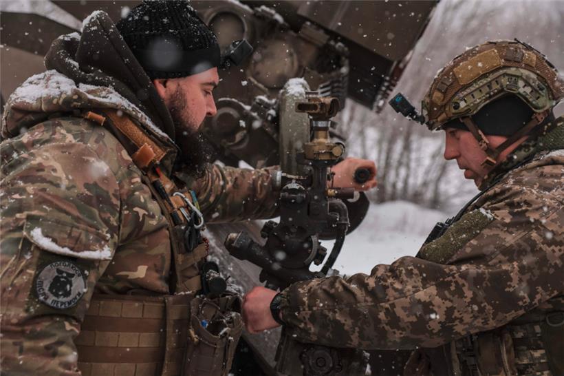 Zwei ukrainische Soldaten stellen an einem Grad-Raketenwerfer die Zielvorgaben ein
