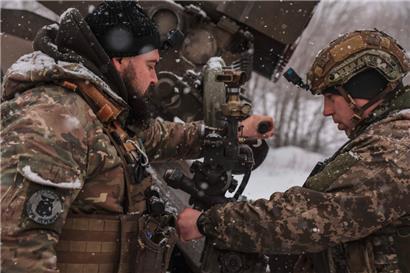 Zwei ukrainische Soldaten stellen an einem Grad-Raketenwerfer die Zielvorgaben ein
