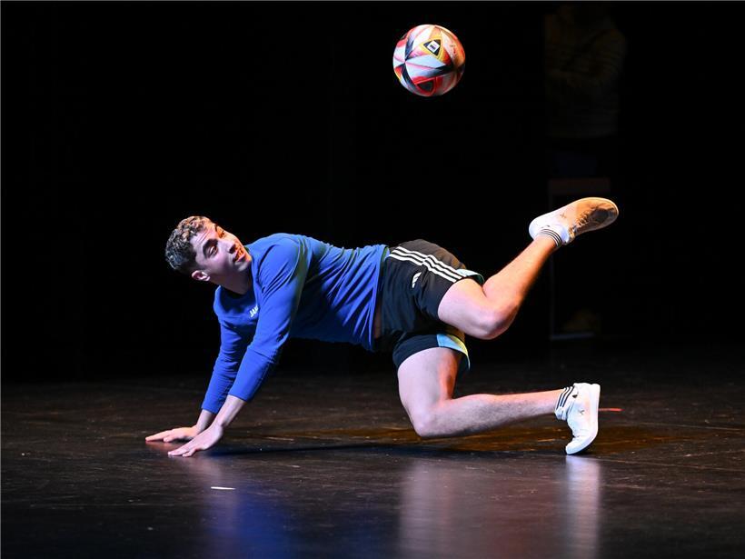 Freestyle Fußball Spieler zeigt beeindruckende Tricks und Ballkontrolle auf urbanem Hintergrund