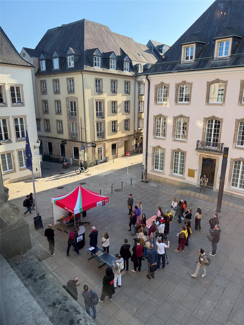 déi lénk Public Viewing vor der Chamber mit Menschen und roter Parteifahne im Freien