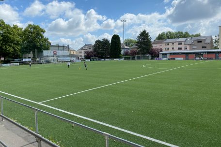 Einige Klassen machen Pause auf dem Fußballplatz neben der Schule